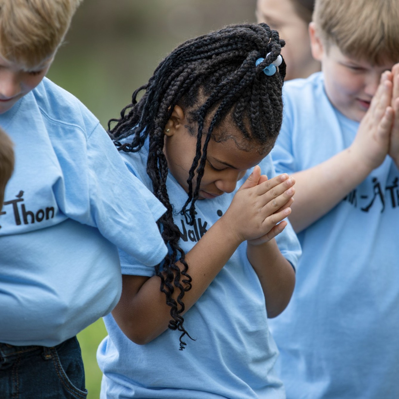 Children standing outside in prayer